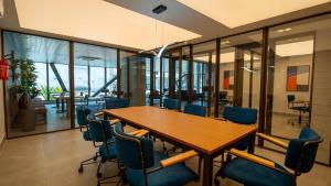 a conference room with a wooden table and blue chairs at Studio Fortal in Fortaleza