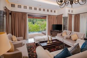 een woonkamer met banken en een tv bij Homm Saranam Baturiti in Bedugul