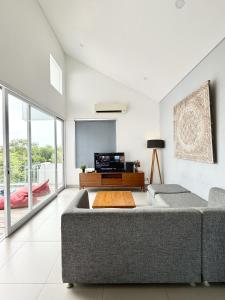 ein Wohnzimmer mit Couch und Flachbildfernseher in der Unterkunft Villa Omah Bali in Uluwatu