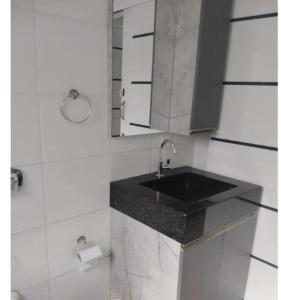 a bathroom with a black sink and a mirror at Hotel Pousada Sol Nascente Mafraa in Mafra