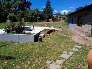 een achtertuin met een zwembad en een tuin met gras bij Rincón de Nina in Tanti