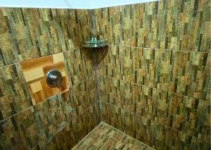 a bathroom with a shower with a wooden wall at Boreirom TeukChhou lodge By JK6 in Phum Mak Prang +78 photos