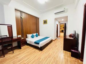 een slaapkamer met een bed, een bureau en een computer bij Khách Sạn Hùng Vương Quảng Ngãi in Quang Ngai +235 foto's