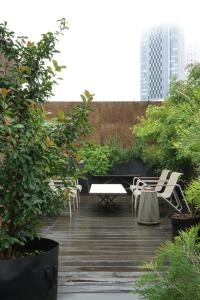 a patio with white chairs and tables and trees at AET & o3 HOTEL in Tokyo