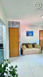 Una sala de estar con un sofá y una puerta de madera. en Recanto da Mary em Morro de São Paulo no Centro e Próximo a Praia, en Morro de São Paulo