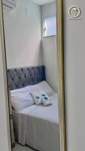 Un espejo que refleja una cama con dos toallas encima. en Recanto da Mary em Morro de São Paulo no Centro e Próximo a Praia, en Morro de São Paulo
