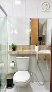 Un baño blanco con inodoro y lavabo. en Recanto da Mary em Morro de São Paulo no Centro e Próximo a Praia, en Morro de São Paulo