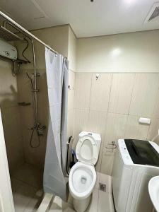 a bathroom with a toilet and a shower and a sink at Shell Residence MOA Pasay by Kathy in Manila