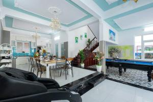 Una sala de estar con una mesa y un comedor. en Villa Hồ Bơi Vũng Tàu Gần Biển - A21 - Free Bida - Phòng Karaoke Máy Lạnh, en Vung Tau