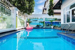 Una piscina con un flamenco rosa en una casa. en Villa Hồ Bơi Vũng Tàu Gần Biển - A21 - Free Bida - Phòng Karaoke Máy Lạnh, en Vung Tau