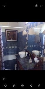 ein Badezimmer mit zwei Waschbecken und einem Spiegel in der Unterkunft Maschwitz casa del agua in Maquinista Savio