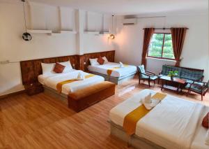 a hotel room with three beds and a couch at Boreirom TeukChhou lodge By JK6 in Phum Mak Prang