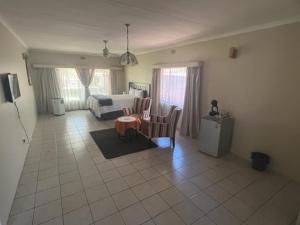 a living room with a bed and a table at Kremetart Villa in Alldays