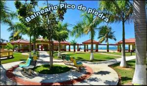 een park met een heleboel bankjes en palmbomen bij Villa Mi casita el paraiso costero in Aguada