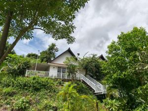 a house on a hill with a porch and trees at Boreirom TeukChhou lodge By JK6 in Phum Mak Prang