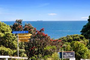 a street sign with the ocean in the background at Beach Studio - coastal escape near Fitzroy Beach in New Plymouth