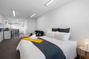 a bedroom with a large bed with a yellow blanket on it at Beach Studio - coastal escape near Fitzroy Beach in New Plymouth