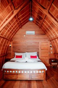 une chambre avec un lit dans une pièce en bois dans l'établissement Nusa Dua Huts Pondok Gajah Para by EPS, à Nusa Dua
