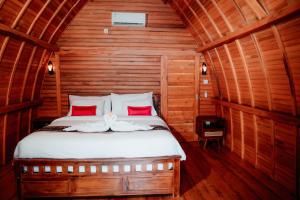 une chambre avec un lit dans une cabane en bois dans l'établissement Nusa Dua Huts Pondok Gajah Para by EPS, à Nusa Dua
