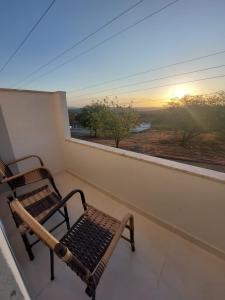 a bench on a balcony with a view of the sunset at Pousada Luz do Sol in Piranhas