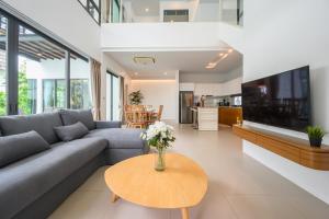 un salon avec un canapé et une table dans l'établissement New Luxury Pool Villa Bangtao Free Electricity & Daily Cleaning, à Ban Pak Lak