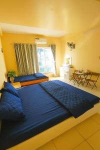 a large blue bed in a room with a window at Nhật Minh Motel Hải Phòng in Hai Phong