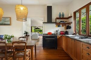 eine Küche mit Holztisch und ein Esszimmer in der Unterkunft Mullum Cottage 10 minutes from beaches in Mullumbimby