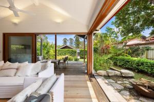 ein Wohnzimmer mit einer weißen Couch auf einer Terrasse in der Unterkunft Mullum Cottage 10 minutes from beaches in Mullumbimby