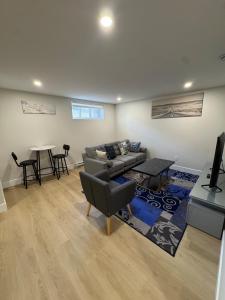 ein Wohnzimmer mit Sofa und Tisch in der Unterkunft Cozy & Stylish Retreat with Modern Comforts in Moncton