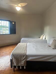 a bedroom with two beds and a window at Oxx Quarto Terra in Congonhas +13 photos