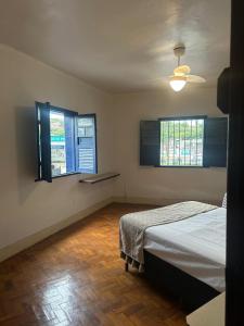a bedroom with two beds and two windows at Oxx Quarto Terra in Congonhas