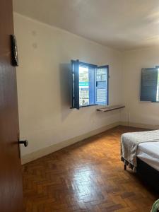a room with a bed and a window at Oxx Quarto Terra in Congonhas