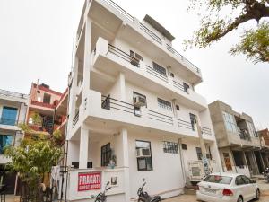 a white building with motorcycles parked in front of it at Hotel O Pragati Inn in Jaipur