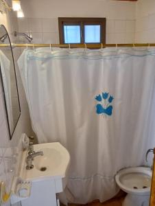 a bathroom with a white shower curtain and a sink at Ruca Melin in Las Grutas
