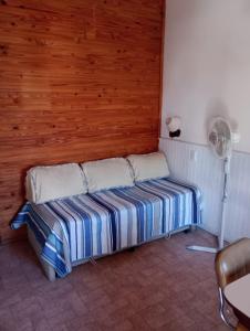 a bed in a room with a fan at Ruca Melin in Las Grutas