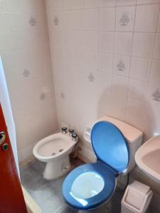 a bathroom with a blue toilet and a sink at Ruca Melin in Las Grutas