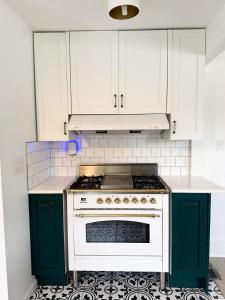 a kitchen with white cabinets and a white stove at Recently Renovated 1924 DUTCH in Royal Oak in Royal Oak +21 photos