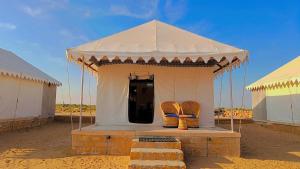 una tienda de campaña blanca con dos sillas en el desierto en Serendipity Desert Dunes Luxury Resort By Royal Empire, en Jaisalmer