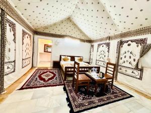 una sala de estar con una mesa y un sofá en Serendipity Desert Dunes Luxury Resort By Royal Empire, en Jaisalmer