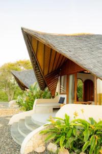 a resort with white chairs and a roof at Elysian Cove - One Bedroom Villa in Sekongkang Bawa