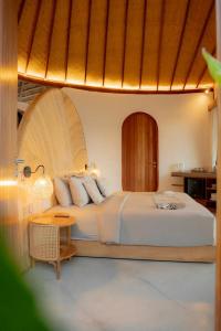 a bedroom with a large bed and a table at Elysian Cove - One Bedroom Villa in Sekongkang Bawa +7 photos