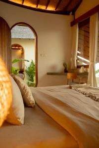 a bedroom with a large bed with a mirror at Elysian Cove - One Bedroom Villa in Sekongkang Bawa