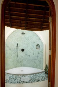 a bathroom with a bath tub in a room at Elysian Cove - One Bedroom Villa in Sekongkang Bawa