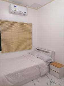 ein weißes Schlafzimmer mit einem Bett und einem Fenster in der Unterkunft Navio Transient House in Cabuyao