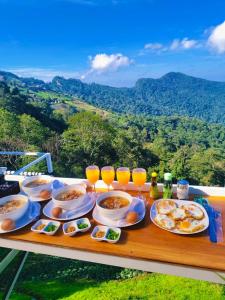 a table with plates of food and glasses of orange juice at เอวาเเคมป์ ภูชี้ฟ้า Avacamp phuchifa in Ban Seng Choi