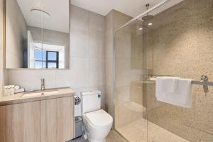 a bathroom with a toilet and a shower and a sink at 409 at CODA - City Convenience Meets Coastal Ease in Coffs Harbour +18 photos