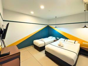 a room with two beds and a desk and a television at Smile Hotel Klang Bukit Tinggi in Kampong Telok Gadong Besar +20 photos