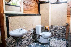 un baño con inodoro y lavabo en Maha Nusa Menjangan, en Banyuwedang 92 fotos más