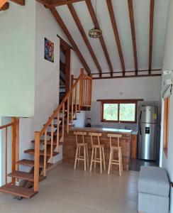 a kitchen with a staircase and a bar with stools at Chalet Villa Serena in Villa de Leyva