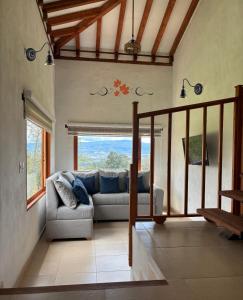 a living room with a couch and a large window at Chalet Villa Serena in Villa de Leyva